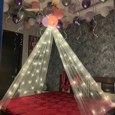 A simple and romantic bedroom canopy decoration. We used a sheer white canopy with fairy lights and surrounded it with pink, purple, and white balloons on the ceiling.