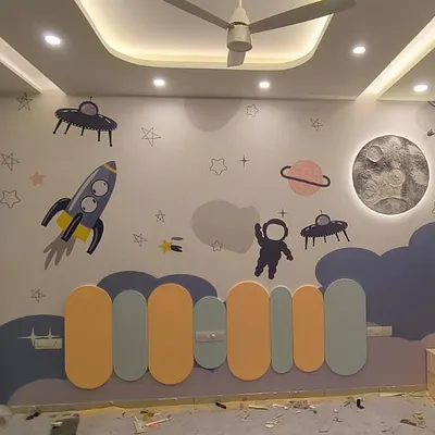 To the moon and beyond! This kids' bedroom features a complete space adventure with rockets, planets, and aliens, centered around a textured 3D moon mural that lights up.