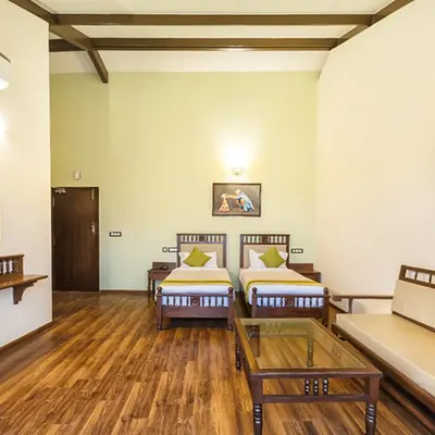 A look inside our twin-bed room, featuring natural wood furniture, a comfortable seating area, and ample space to relax. The room is designed to be a peaceful haven for your stay.
