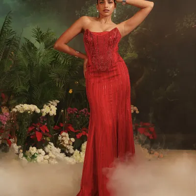 The Bellerose Gown in a passionate red, designed for making an unforgettable entrance. The structured corset and mermaid silhouette are meticulously crafted for a flawless fit, perfect for a gala or formal wedding reception.