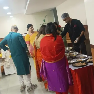 A chef interacting with guests while preparing fresh chaat at a live counter. This adds a personal and entertaining touch to any house party.