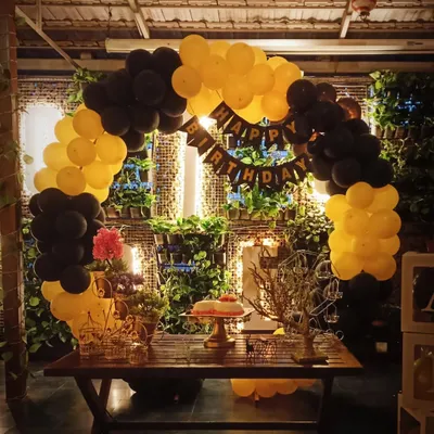 This birthday setup in a cafe features a rustic and chic design. We used a black and yellow balloon arch to complement the venue's greenery wall and wooden furniture, creating a stylish and coordinated look.