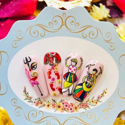 This hand-painted nail art set for Navratri features iconic motifs like the Goddess's eye, her footprints, and Garba dancers, showcasing the detailed character work we teach.