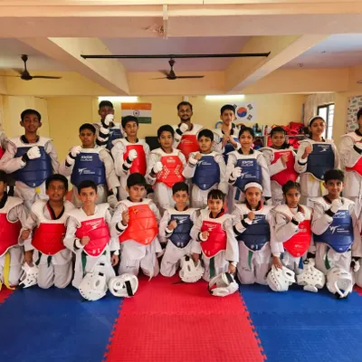 The team is ready for their belt exam. Wearing their protective gear, they are prepared to demonstrate the skills they've learned.