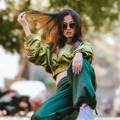 A dynamic low-angle shot from a street style session. The model's pose is strong and confident, and the movement in her hair adds a sense of action and spontaneity.