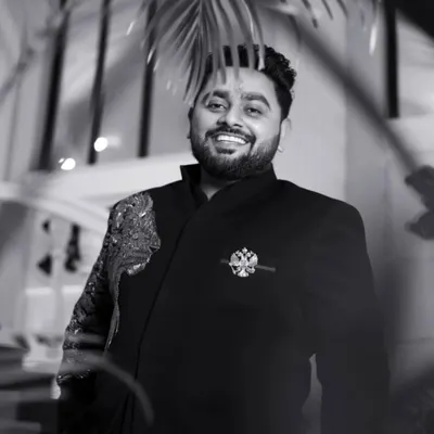A timeless black and white portrait of the groom, Rajat, his confident smile captured perfectly. This shot shows his charm and readiness for the big day.