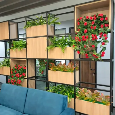 For this office, we created a functional and beautiful partition wall using a combination of artificial foliage and flowering plants. This is an excellent solution for dividing spaces while maintaining an open, green feel without any maintenance.