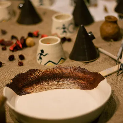 A beautiful spread of student work from our 'Glazed '22' exhibit. This shot features a stunning wave-carved serving dish, perfect for making a statement at your next dinner party.