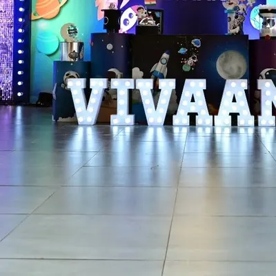 My marquee letter rentals are perfect for personalizing any event space. Here, they spell out the birthday boy's name, "VIVAAN," in bright lights against a space-themed backdrop.