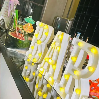 A close-up of our illuminated "BAR" sign on a sleek, modern bar counter. This decorative element adds a professional and festive touch to any event space.
