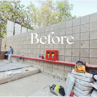 Before: A large, plain retaining wall at a project site. This space was functional but lacked any visual appeal or connection to nature.