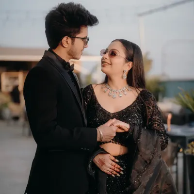 A stylish portrait of Mohit and Priyanka at their reception. Their coordinated black outfits and confident poses exude modern elegance.