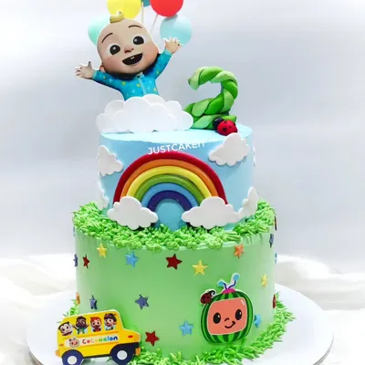 This two-tiered Cocomelon cake is full of cheerful details, including a rainbow, balloons, and the iconic school bus. The chocolate truffle cake inside was a big hit at the second birthday party.