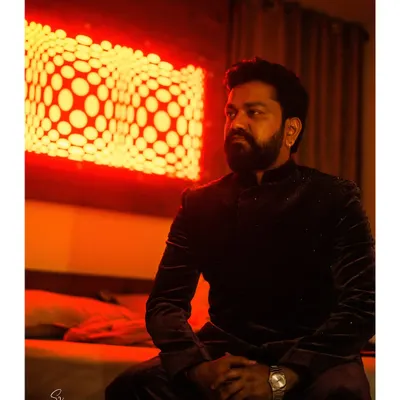 A stylish and moody portrait of the groom, captured with dramatic red lighting that creates a cinematic effect.
