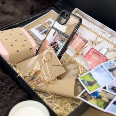 An overhead view of a packed gift hamper, showing how all the different elements come together. You can see the custom phone cover, polaroids, resin keychain, and other handcrafted items nestled in the box.