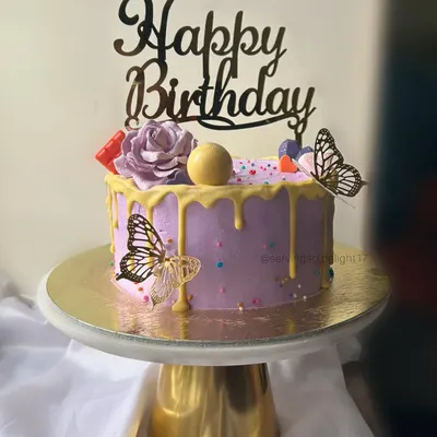 A lovely lavender birthday cake with a yellow drip, buttercream roses, and delicate butterfly accents. This design is both playful and elegant.
