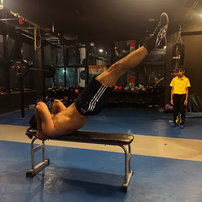 Core strength is non-negotiable. An athlete performs intense leg raises on a bench, a key exercise for building the stability needed for combat sports.