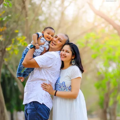 There's nothing better than a candid laugh. This outdoor family portrait, taken during the golden hour, captures a moment of pure happiness and connection.