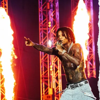 Swae Lee brings the heat to Rolling Loud India, performing shirtless against a backdrop of towering flames. This is a prime example of capturing high-energy pyrotechnic moments during a live rap performance.
