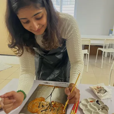 A participant adding shimmering gold foil to her painting. This technique adds a beautiful, luxurious finish to any artwork.