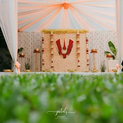 This Nalugu decor for a Telugu wedding beautifully blends tradition and elegance. The backdrop of white chrysanthemums is centered with a bold red Balaji Nama, creating a divine and auspicious atmosphere for the ceremony.