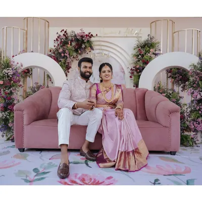 A picture-perfect moment for the newly engaged couple. I used a plush dusty rose sofa and a modern backdrop with cascading purple and pink flowers to create a romantic and stylish setting for their ring ceremony.