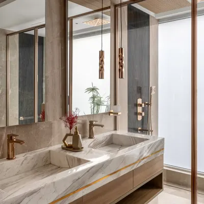 We believe bathrooms should be private sanctuaries. Here, we used exquisite white marble for the integrated double sink, paired with warm wood cabinetry and rose gold fixtures. Details like the backlit mirror and frosted glass shower partition create a spa-like atmosphere that is both functional and serene.