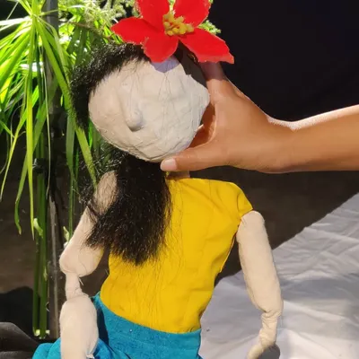 A close-up of one of our handmade puppets, showing the delicate features and the flower in her hair. The details bring her to life.