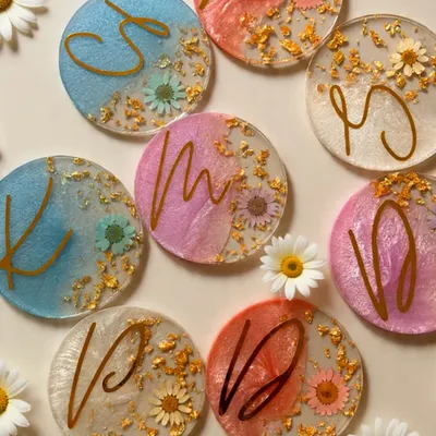 Our resin initial coasters are a beautiful and practical wedding favor. This styled shot shows how we embed dried daisies and gold flakes for an elegant, personalized touch.