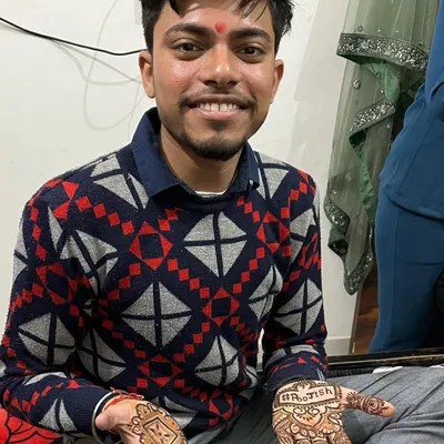 A happy groom showing off his wedding mehndi. It's common to include the bride's name, as seen here with "Ashish," making it a sweet gesture.