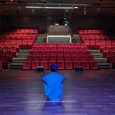 A quiet moment on stage, sitting in front of the empty seats before the 'Beyond Impossible' show. This is where the dream, the planning, and the prayers all come together.