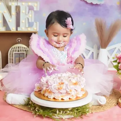 The best part of a cake smash. This little princess is digging into her first birthday cake with pure delight.
