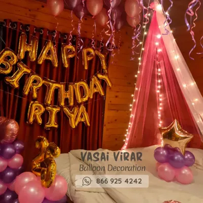 We love creating romantic surprises! This bedroom decoration features a dreamy pink canopy with fairy lights over the bed, surrounded by pink and purple balloons. The personalized "Happy Birthday Riya" foil balloons make the celebration feel extra special.