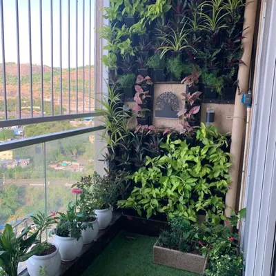 A private balcony transformed into a lush, green retreat. This vertical garden installation maximizes the small space, creating a vibrant wall of life that improves air quality and provides a beautiful city view.