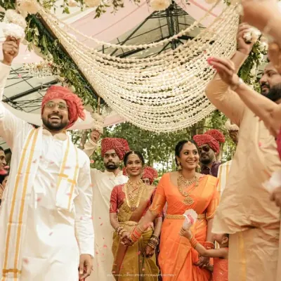 The grand exit, showered with flowers and blessings. This wide shot captures the immense joy of the couple and their families at the conclusion of the ceremony.