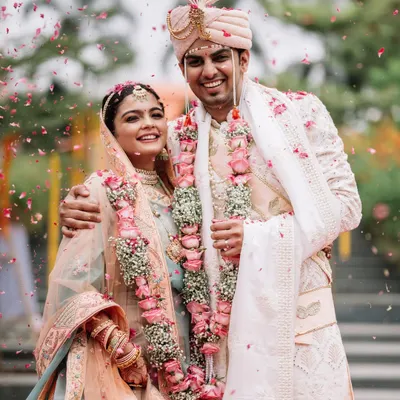 The moment right after the Varmala, with rose petals still in the air. Disha and Prateek are just beaming. This is what it's all about, capturing that pure, post ceremony glow.
