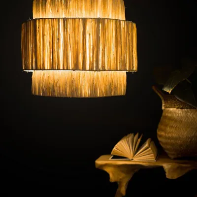 I love experimenting with different textures, and this tiered lampshade is crafted from raw natural fibers to create a rich, layered effect. When lit, it radiates a gentle, warm light that highlights the material's organic quality.