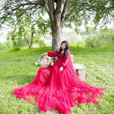 Taking the magic outdoors. This beautiful portrait was taken in a lush green park, with the vibrant red gown creating a stunning contrast against the natural scenery.