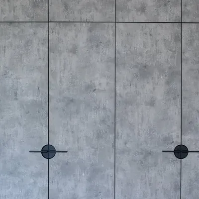 A close-up of the concrete-finish wardrobe doors with unique circular handles. This is what happens when function meets beauty and smart design meets real life.