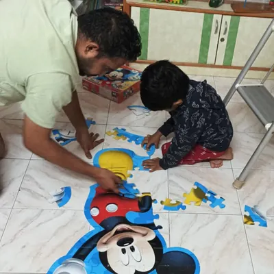 A father and son work together to solve a giant Mickey Mouse floor puzzle. It’s moments of teamwork and shared accomplishment like this that make the library a special place for families.
