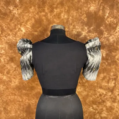 Classy and bold. This black blouse features dramatic puff sleeves in a contrasting print and a flattering sweetheart neckline. The front hook closure ensures a perfect, seamless fit.