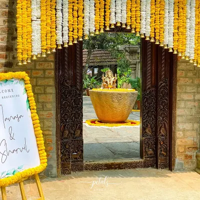 A traditional welcome to our beginning. The entrance to this heritage venue is framed by a beautiful toran of marigolds and chrysanthemums, with a matching floral border on the welcome sign.