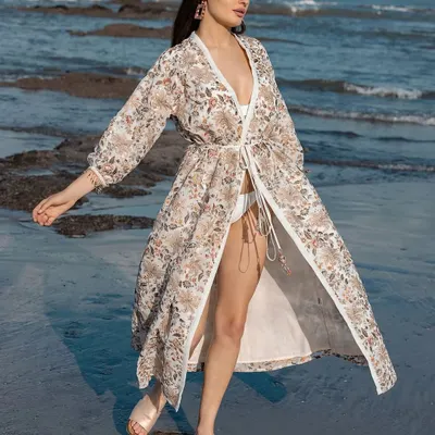 A beautiful shot of a model in a floral print kimono, styled for a resort wear brand. The look is perfect for a stylish beach day.