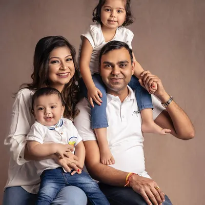 A perfect casual family portrait. Dressed in classic white and denim, this family of four radiates pure happiness and relaxed connection.