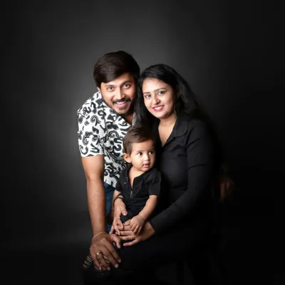 A classic family portrait against a dark backdrop. The focus is entirely on their happy expressions and the bond they share.