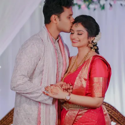 A tender moment from an engagement ceremony, where the groom kisses the bride's forehead. This candid shot captures the love and emotion of the occasion.