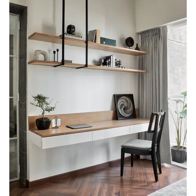 This floating study desk in white and natural oak is a perfect example of my minimalist yet functional design. The suspended open shelving keeps the space feeling light and airy, while the herringbone wood floor adds warmth and texture.