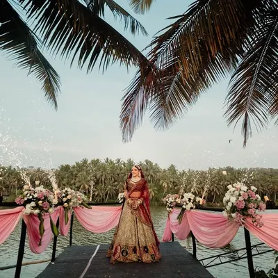 For a truly unforgettable bridal arrival, I designed this stunning waterside entrance. The bride stood poised against a backdrop of lush palm trees and shimmering pyrotechnics, creating a moment of pure drama and elegance.