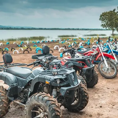 Our fleet of ATVs and dirt bikes is ready for your team. Lined up by the lake, these vehicles are your ticket to an exciting race or a guided tour around our scenic off-road track.