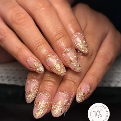 An absolutely regal set for a bride-to-be. This design features intricate, hand-sculpted 3D gold art and delicate pearl accents over a soft, natural base for a truly luxurious finish.